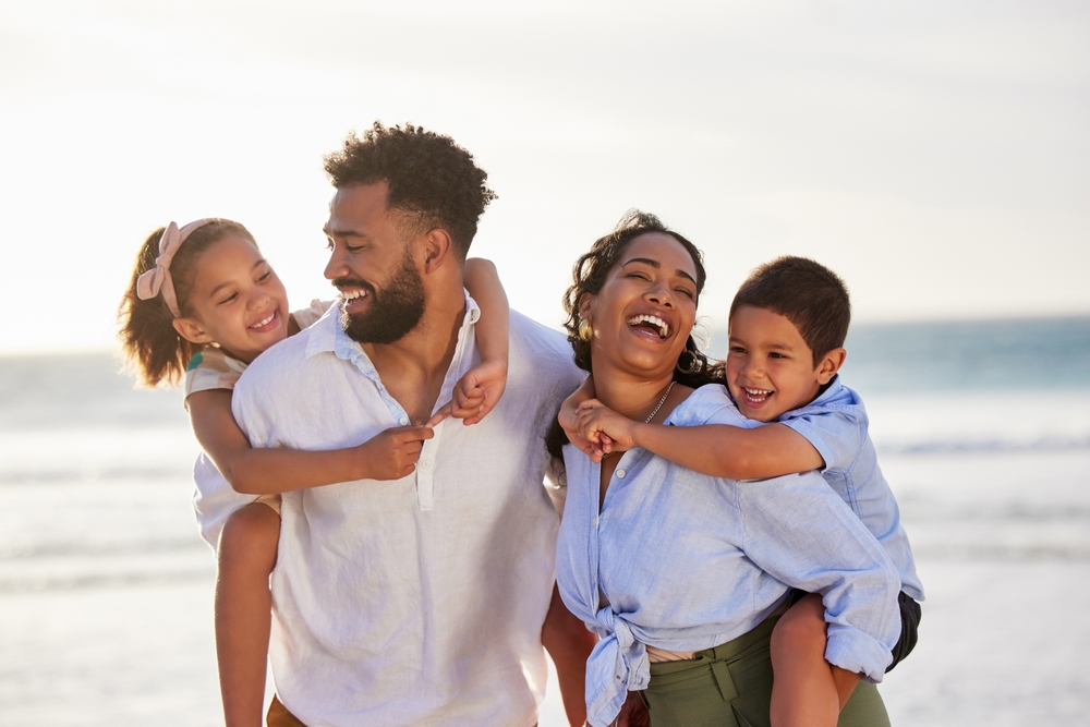 Smiling family taking a cheerful beach selfie at sunset – Point Loma Dentist